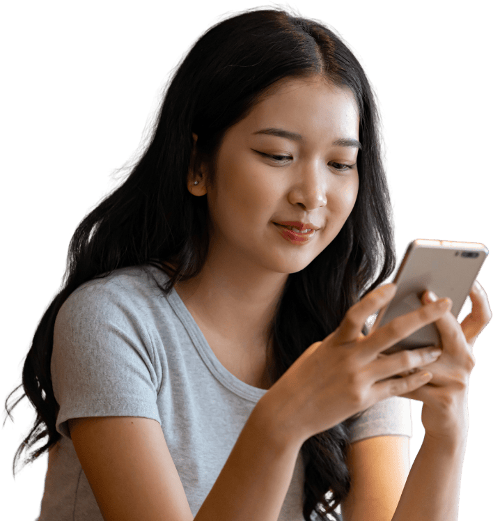 Young woman smiling while reading a text message on her phone